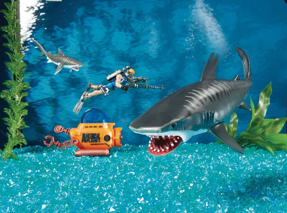 Фото игрушечной акулы на зеленом фоне